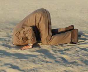 man burying his head in the sand