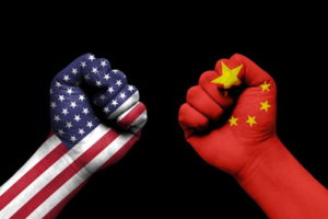 two fists one with us flag one with china flag